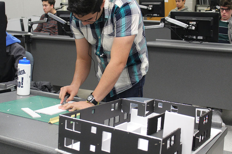 Senior Gabriel Maisonet measures and slices foam in order to build a model house in his 5th period Drafting Class on January 18. “I am making a house out of the 3D model that I designed,” Maisonet said. So far it’s taken me about two weeks.”