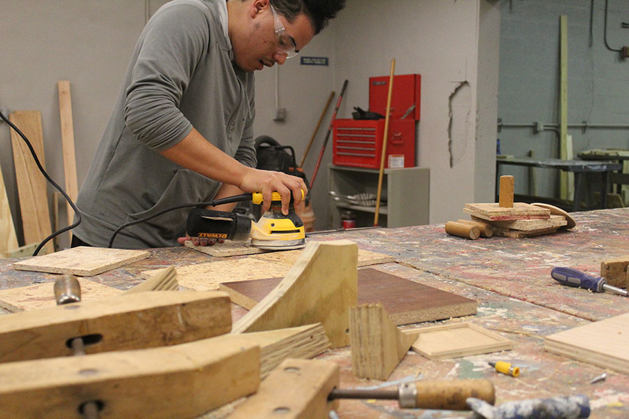 Senior Antonio Marquez sands wood in order to construct his assignment during his Building Trades and Construction Design Technology class on February. 7. Students build a variety of items, from toolboxes and stools to fuse ball tables.