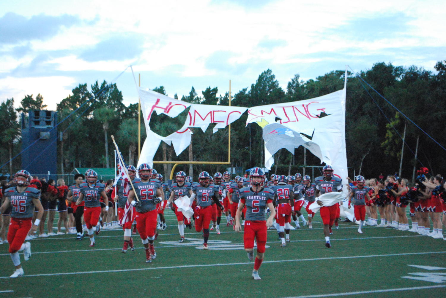 On Friday, September 21st, the varsity football team charges through the banner to start the game. The Patriots won the game, with a final score of 35-28