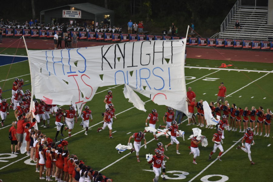 On Friday, Oct. 11, the varsity football team tears through the homecoming banner as they begin their game. The game was the first on the newly re-turfed Tom Storey Field.