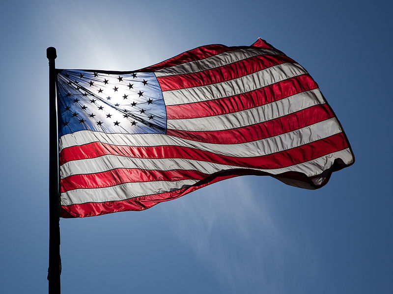 Flag of the United States of America, backlit, on a windy day.