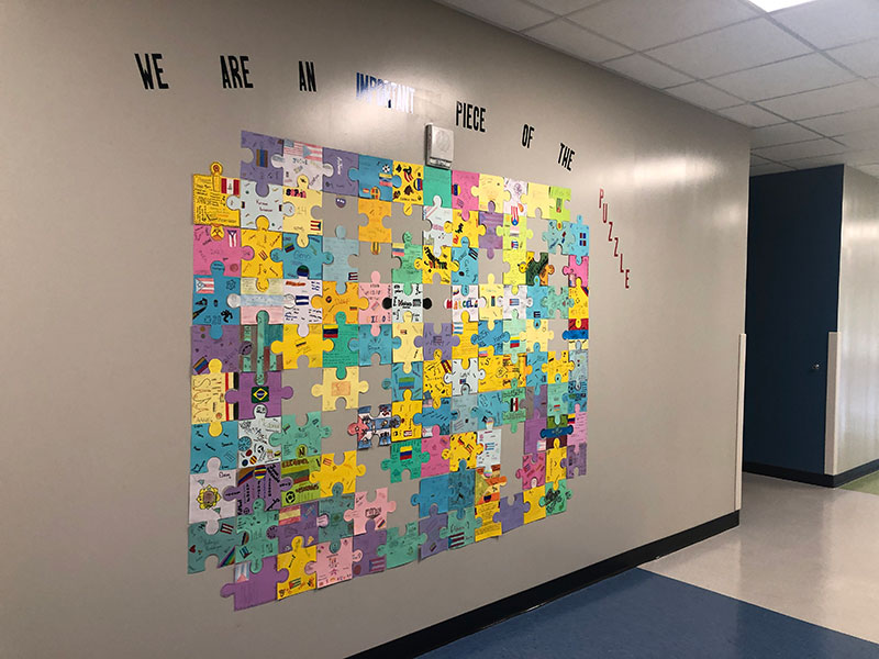The wall outside of the ESL classes in Building 5 display a puzzle made up of pieces created by students in the ESOL program on August 30.