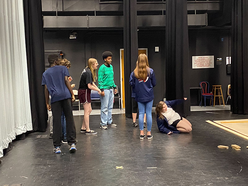 Troupe members cool off with a fun game of limbo while waiting for something to do. Work days can often be slow, but the end product of the set is very rewarding.