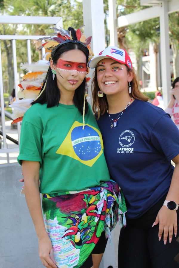 Senior Kamilly Batista, representing her Brazilian heritage, poses with junior Melody Montero at the festival on Friday, Oct. 15.