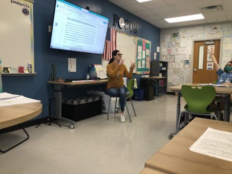 English teacher Audra Greuel sits in front of her students in her classroom, taking questions and encouraging class discussion about assigned reading. In order to nurture a friendly academic environment, she participates in back-and-forth dialogue with the class, exchanging ideas and thoughts.