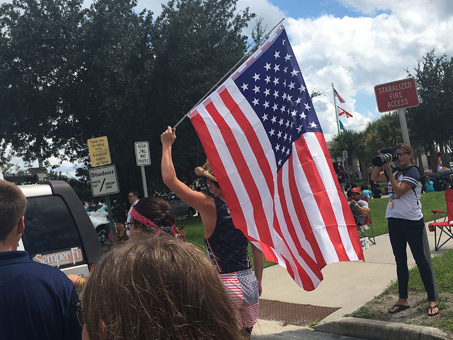 Junior Logan Turner, who placed in the top ten for Freedom Thursday, walks in the parade. He occasionally sprinted, while waving his American Flag in the air.