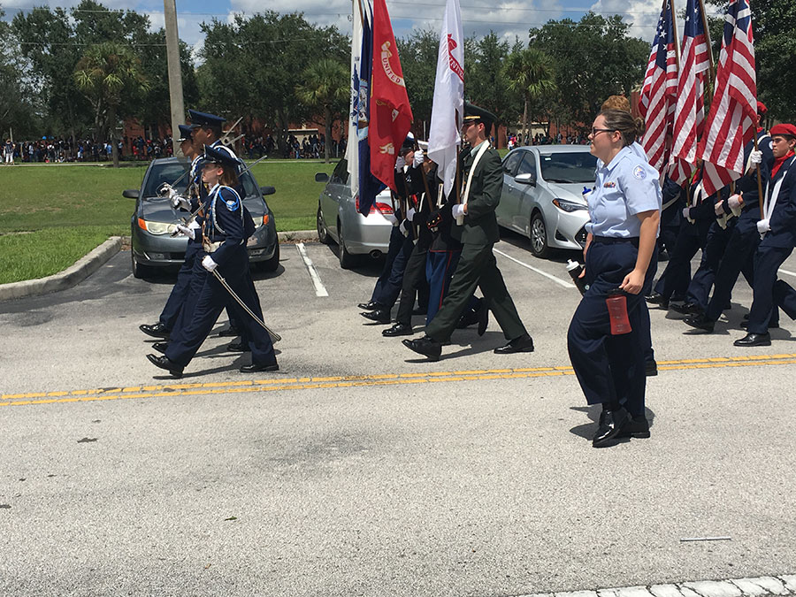 The Lake Brantley Air Force Junior Reserve Officer Training Corps (AFJROTC) Color Guard passes by, with their assistants. Unable to break formation, the JROTC Color Guard has people walking beside them with water to keep them hydrated throughout their march.