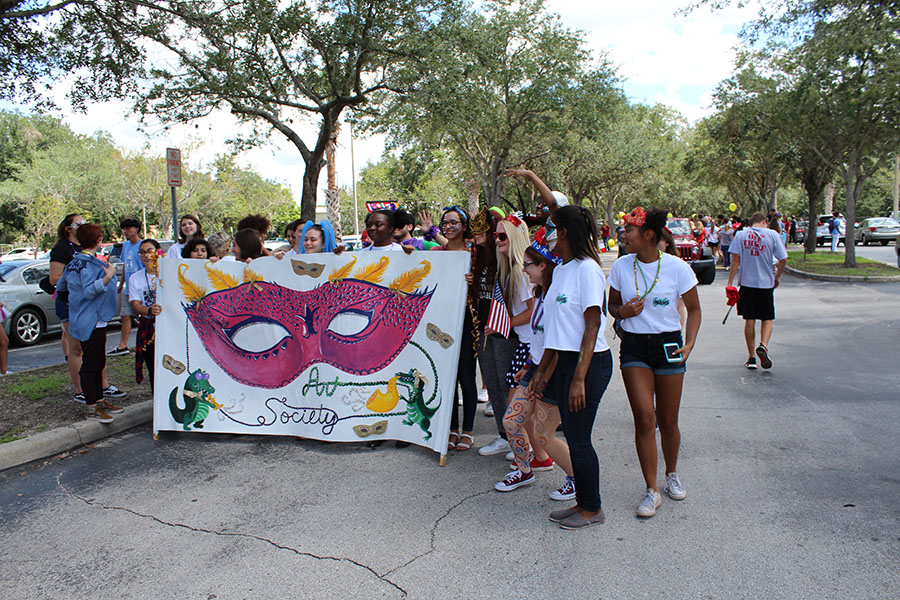 The Art Honor Society shows a handmade banner to they painted to walk with during the Homecoming Parade on Thursday September 7. Over 20 talented students showed their club pride and school spirit. 