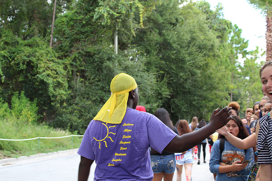 Members of the sunshine club high-five spectators as they run by while walking in the parade on September 7. Many students enjoyed interacting with the parade watchers and hyping up the crowd. 