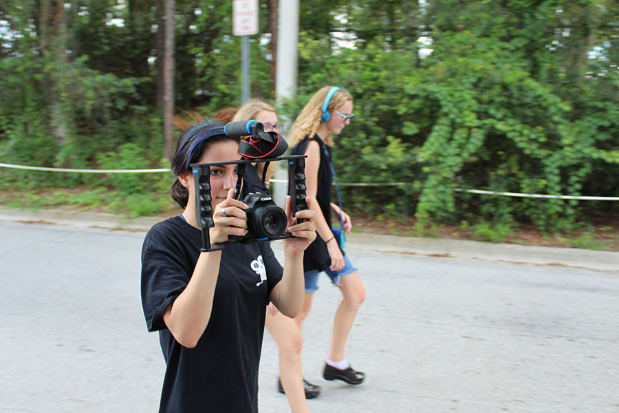 Senior Beatriz Arroch films the parade while walking with Film Club in the homecoming parade on september 7. A variety of clubs and activities, such as Film Club, and sports like Crew all showed their school spirit by walking in the parade. 
