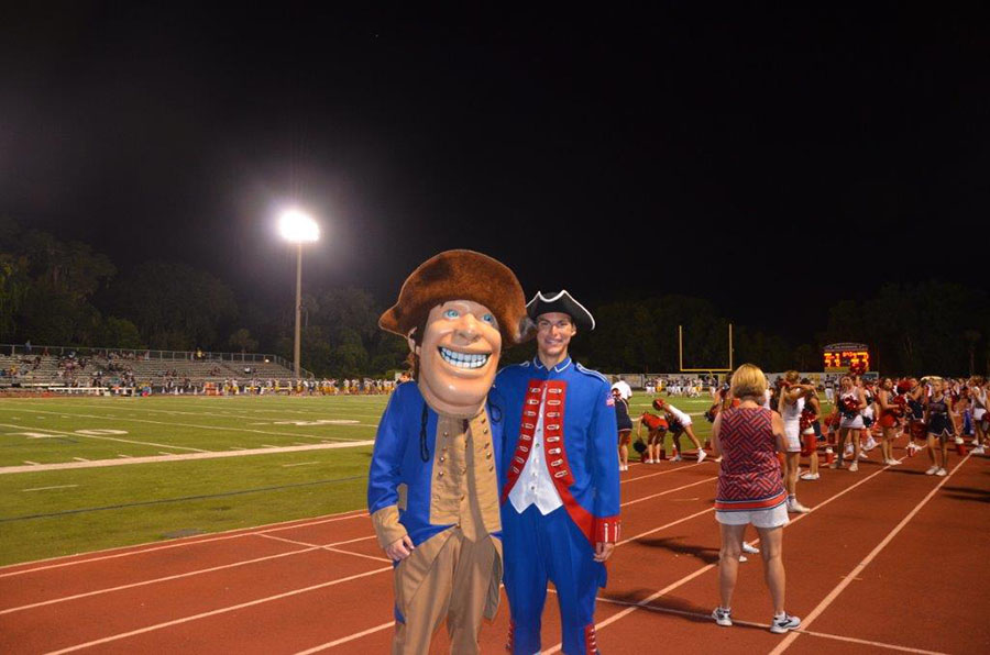 During the homecoming football game on September 7,homecoming king Matt Little and Patriot Pete pose for a picture during halftime. The homecoming king and queen were announced prior to the start of the football game.