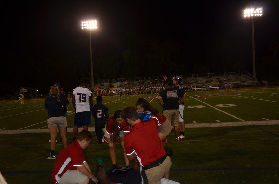Athletic trainers Keano Suarez, Ivanna Suarez, Angel Carbajal, and Kayla Padilla assist an injured football player on Thursday September 7. Instead of being on a Friday, the game had been moved up in the hopes to avoid cancellations from Hurricane Irma. 