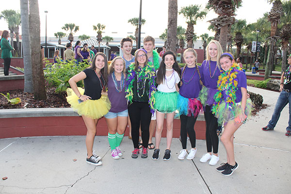 A group poses together prior to the Fat Tuesday theme day voting near the amphitheater as they prepare to parade on the stage. The group then participated in the costume voting and walked across the stage.
