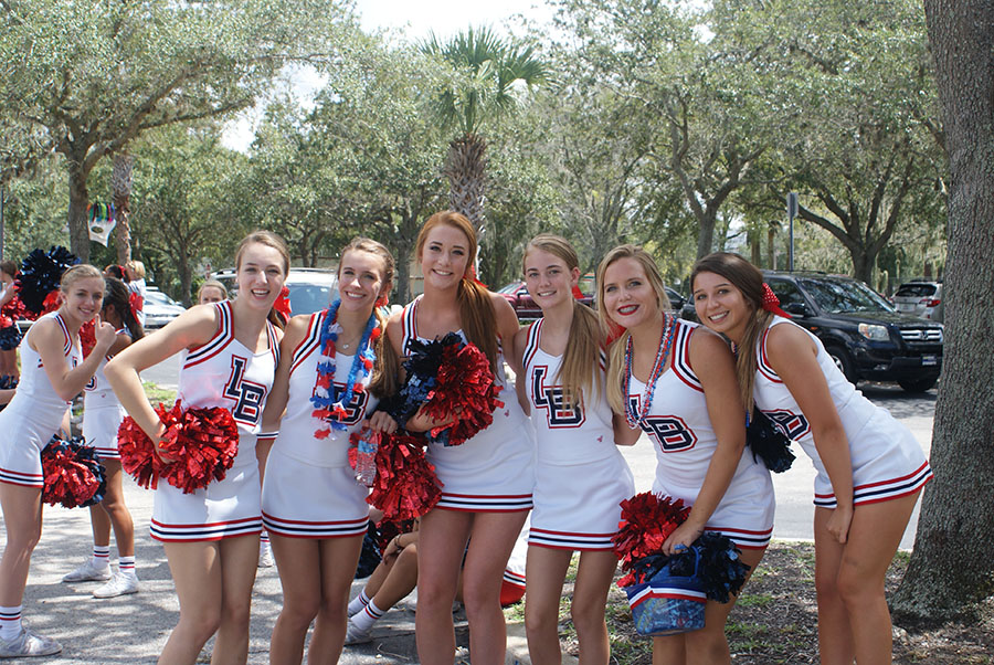 A group of varsity cheerleaders pose in the student parking lot as they wait for the parade to start on September 7. The freshman, junior varsity, and varsity cheerleaders all lead their classes and hold up banners.