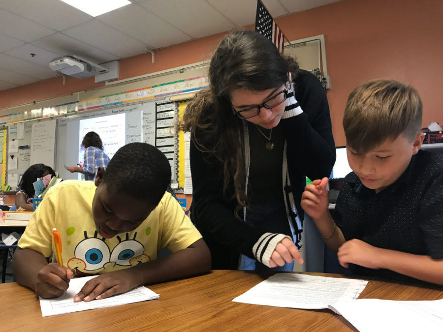 On Tuesday, Oct. 17, during tutoring at Forest City Elementary, junior Emma Murphy helps students A’kai Wallace and Jaiden Stokes with their reading packet. Emma spent over an hour helping the students at after school tutoring.