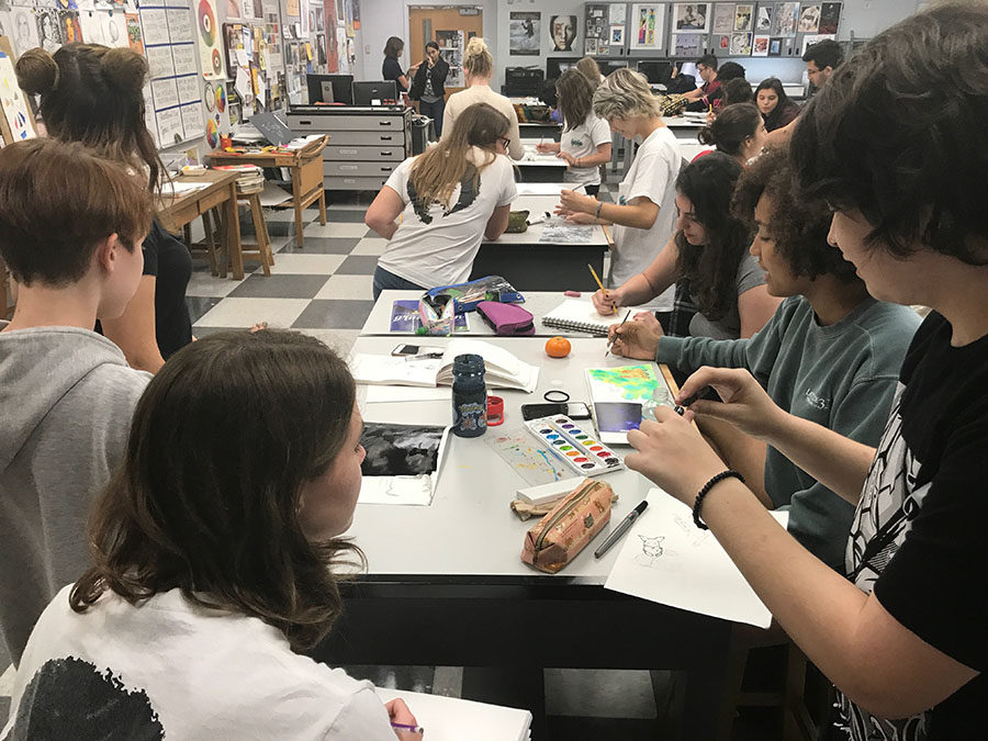 The members of National Art Honor Society all interact with one another while drawing in their sketchbooks during the meeting on Friday, Oct.6. Students then voted on other club issues, like t-shirt design.
