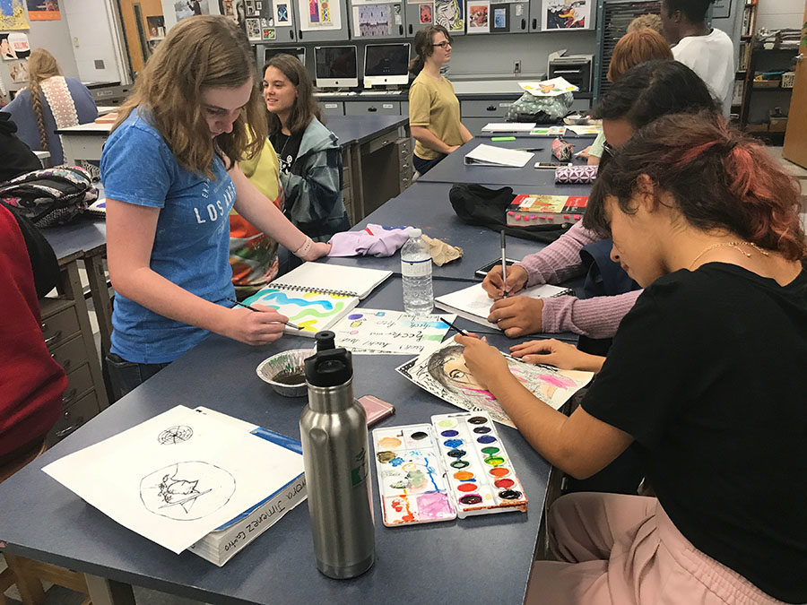 Sophomore Alicia Steffy, Aurora Jimenez, and Giselle Hernandez illustrate with a variety of mediums, including watercolor, in their sketchbooks during the National Art Honor Society meeting on Friday, Oct. 6. The students allotted time for their work to dry before moving on to further detail. 
