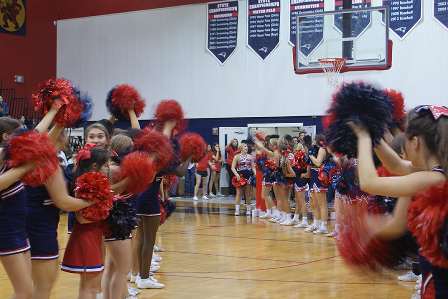 The cheerleaders join together in the main gym to form a path for the varsity football players to run through as they are introduced during the pep rally on Thursday, September 28. The line-up has happened at every pep rally and is a school tradition.