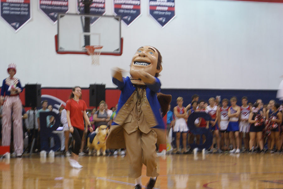 Patriot Pete dances across the gym floor during a transition between performances during the pep rally on Thursday, September 28. He bounced around and tried to excite the crowd for the next performance.