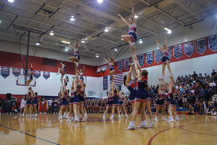 Varsity cheerleaders execute their “elite” stunts during their performance in the pep rally on Thursday, September 28 in the main gym. The elite stunts included a variety of stunts such as full extensions or basket tosses.