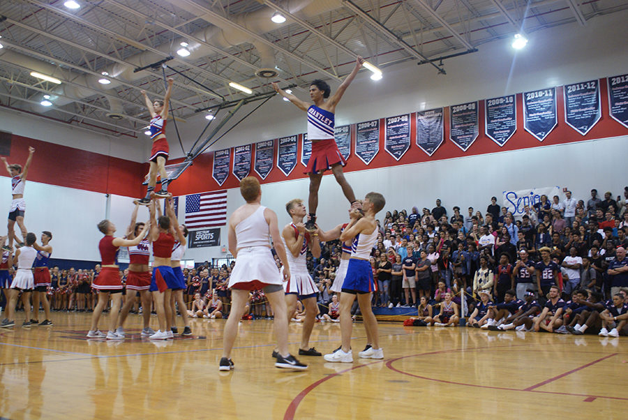 Senior powderpuff cheerleaders execute stunts on Thursday, September 28 in the main gym. They performed stunts similar to those that the cheerleaders engaged in.