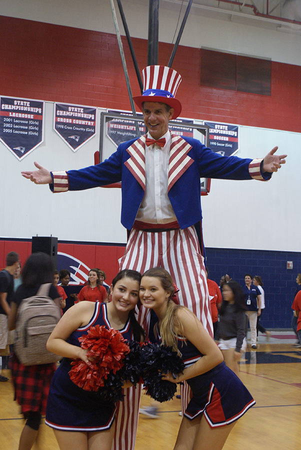 Sophomores Lauren Alonso and Jade Johnston pose for a photo with an entertainer at the end of the pep rally on Thursday, September 28 in the main gym. The entertainer hired by Leadership is experienced in participating in this type of event.