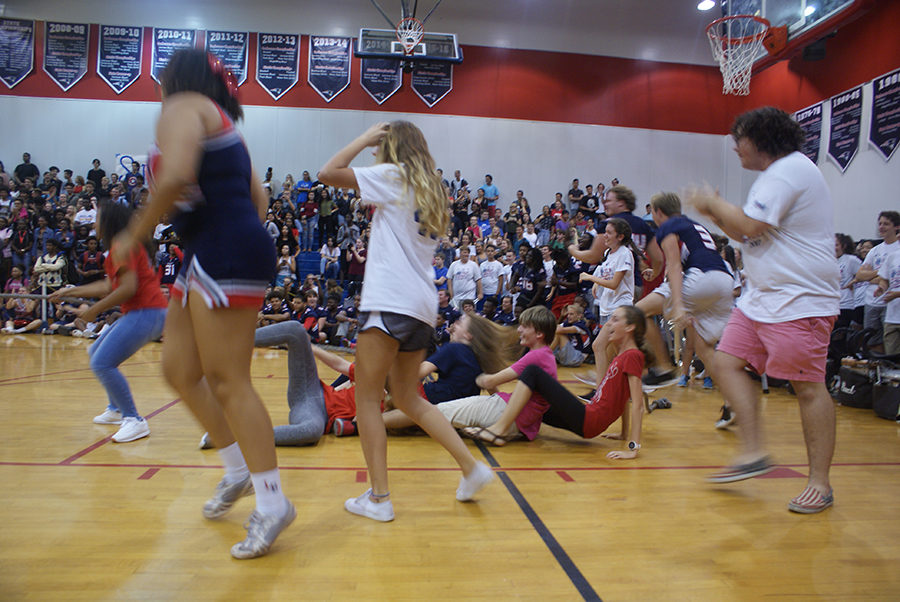 The student side of the “tug o’ war” match crashes to the ground after winning during the pep rally on Thursday, September 28 in the main gym. The students competed against their parents who are teachers and staff at Lake Brantley High School.