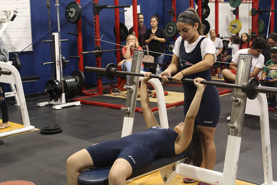 Sophomore Sabina Hincapie competes in the first meet of the season on Wednesday, Nov. 1. She lifts 55 pounds as senior Nellie Scalise spots her.