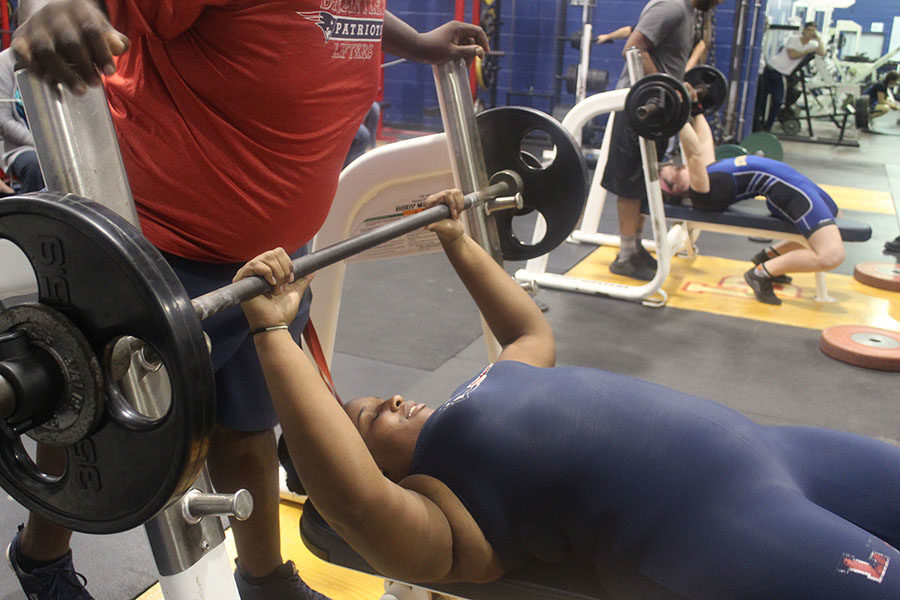 Senior and team captain Destinee Norman gets ready to lift 115 pounds while her coach spots her. On Wednesday, Nov. 1, Lake Brantley held their first meet, but lost to Lyman by eight points.