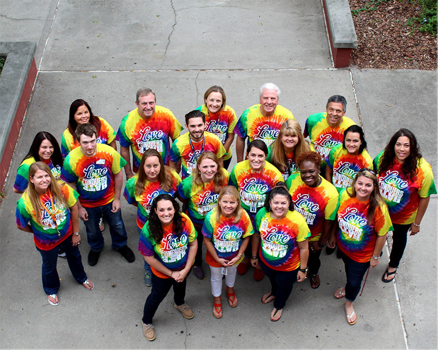 A+group+of+Lake+Brantley+High+School+teachers+pose+together+in+the+courtyard+as+they+show+their+support+to+all+students+by+wearing+their+%E2%80%9CLove+Conquers+Hate%E2%80%9D+shirts+on+Monday%2C+Oct.+23.+Applied+Technology+teacher+Angela+Cecere+and+other+teachers+were+concerned+about+the+protest+that+was+supposed+to+take+place+the+same+Monday+and+ordered+the+shirts+to+show+support+to+students.+%E2%80%9CWe+felt+like+we+had+to+do+something+that+would+show+support+to+all+students%2C%E2%80%9D+Cecere+said.+%E2%80%9C%5BWe%5D+felt+like+wearing+%5Bthe+same%5D+shirt+would+do+that%2C+so+we+agreed+upon+a+design+and+the+look+%5Bfor+the+shirts%5D.+We+all+wore+them+on+that+Monday.%E2%80%9D