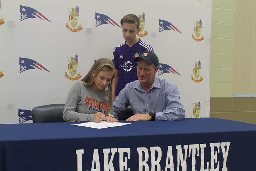Senior Lauren Sniffen signs early to Syracuse University in the community room on November 8 with her family members. Signing to Syracuse means attending the school and being on their crew team.