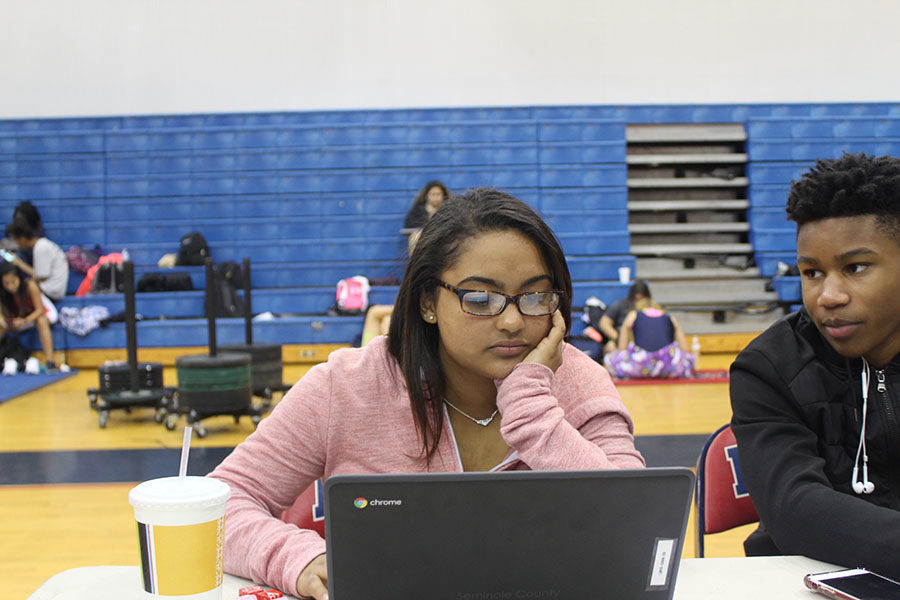 Sophomore Tanica Torres listens to junior Walter Godfrey while preparing for the regional meet on Jan. 18 at the Lake Brantley Main gym. Lake Brantley competed at the girls regional weightlifting meet.