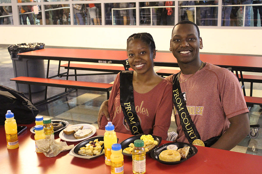Seniors Wilson Valentin and Jodianna Dorvil sit beside each other and eat together on Friday, Apr 6 during senior breakfast in the cafeteria. Valentin and Dorvil were both part of the prom court and were crowned king and queen.