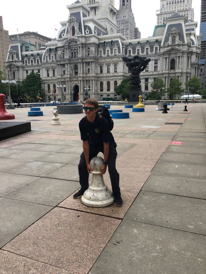 Junior Brett Feldman makes an attempt to play chess with the scattered chess pieces in front of the Municipal Services Building. Feldman made multiple attempts to move it, but they were to no avail.