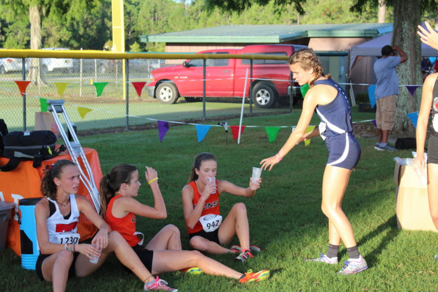  Junior Ashley Klingenberg hands water to other runners on the Oviedo girls cross country team after the Deland Invitational race on Sept. 1. Many teams from various areas of central Florida, including Oviedo High School, participated in the meet.
