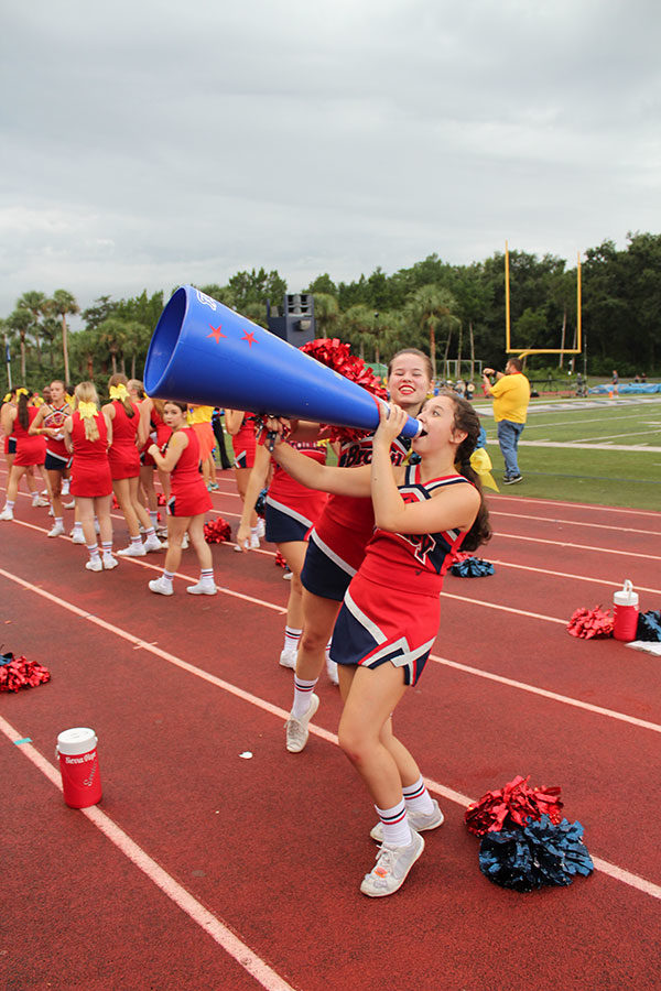 Senior Jamie Benghiat uses the megaphone to hype up the crowd and spur on a chant for the team during a play. The football game against Hagerty High School took place on Friday, Aug. 24 on Tom Storey Field, with the Patriots winning with a score of 35-17. 