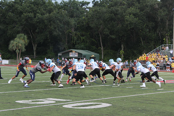 Football players line up in preparation for the next play. The football game against Hagerty High School took place on Friday, Aug. 24 on Tom Storey Field, with the Patriots winning with a score of 35-17. 