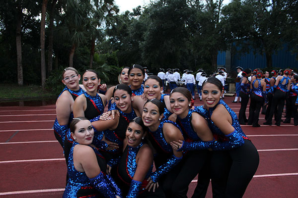 The dancers pose for a photo during their halftime show preparation where they stretch and practice parts of their routine. The football game against Hagerty High School took place on Friday, Aug. 24 on the Tom Storey Field, with the Patriots winning with a score of 35-17. 
