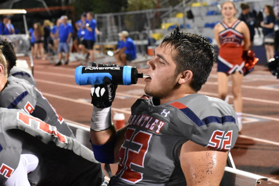 Senior Cade Cecere take a drink of water after playing in the varsity football game. The Patriots won the game against Orange City University, 35-28
