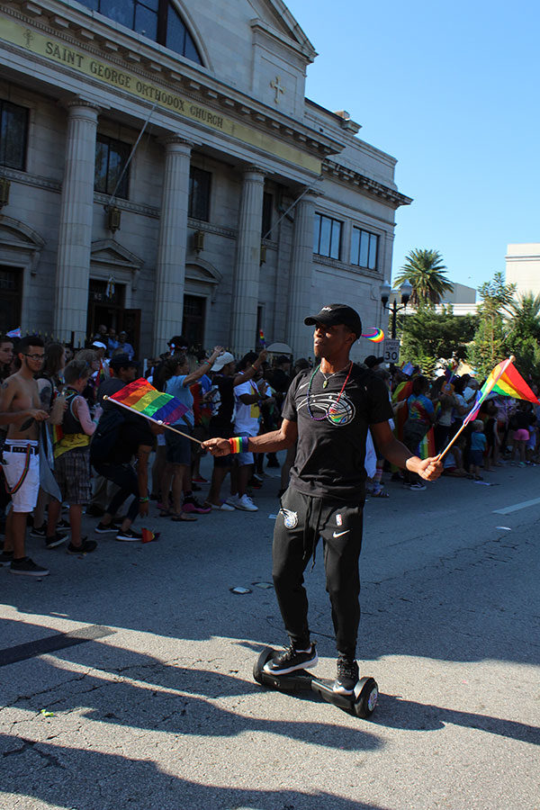 A man with the Orlando Magic rides a hoverboard and waves pride flags as he hypes up the crowd for the Orlando Magic cheerleaders. The LGBT+ community and allies celebrated Orlando Pride on Saturday, Oct. 13, at Lake Eola from 10 A.M. to 10 P.M..
