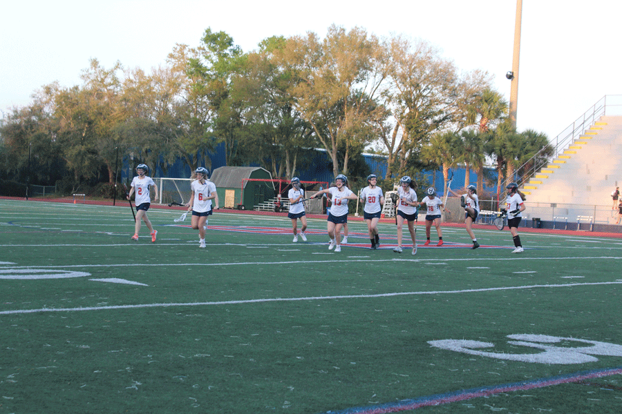 On  Monday, March 4 junior varsity’s starting lineup takes the field as their fellow team members cheer them on to aid their victory in the upcoming game. The junior varsity and varsity girls lacrosse teams played against Winter Park High School in Darwin Boothe Stadium with the junior varsity team winning at 10-4 and the varsity team losing at 8-10. “It [the win] was awesome, I love to see how excited and how happy our team gets after we win a game,” sophomore and JV player Abby Arace said.