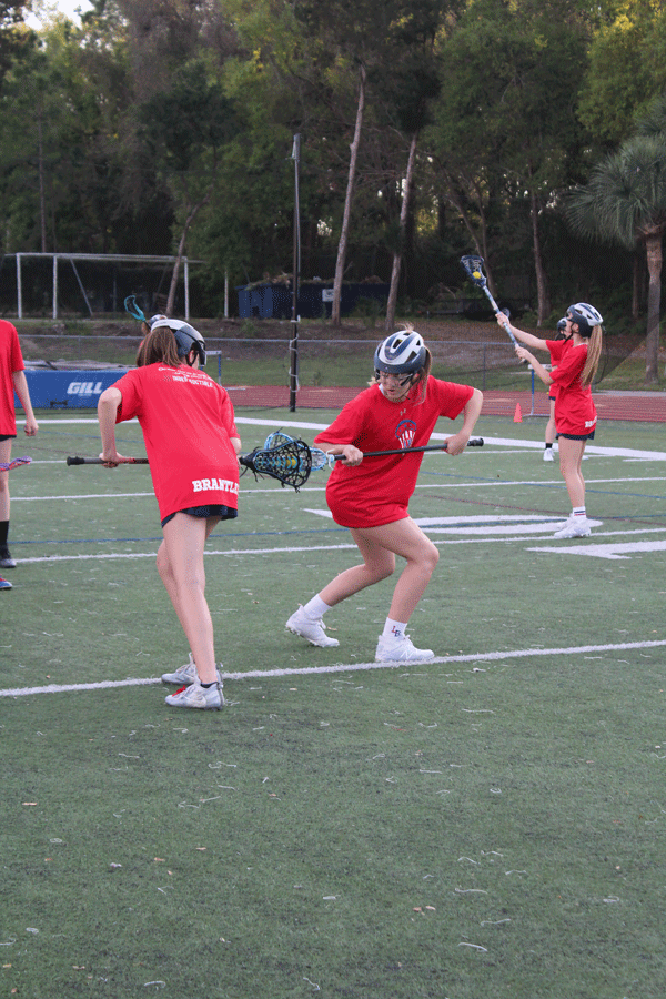 Junior varsity members practice their skills at completing a draw in preparation for the upcoming game on Monday, March 4 .The junior varsity and varsity girls lacrosse teams played against Winter Park High School in Darwin Boothe Stadium with the junior varsity team winning at 10-4 and the varsity team losing at 8-10. “It is so helpful to go over plays and defensive positions before our games,” junior and varsity player Joelle Wittig said. “It refreshes everyone’s memories on what to do and helps us feel more mentally prepared to play our best against the opposing team.”