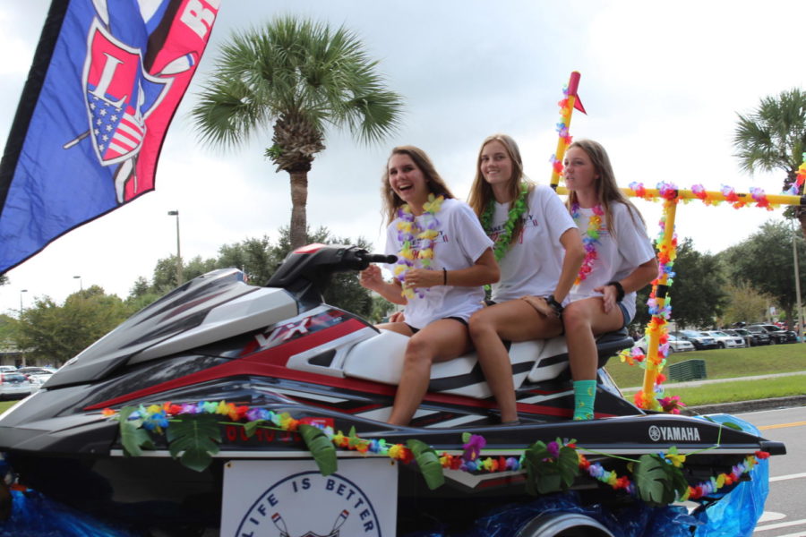 Junior Brianna Nardelli, sophomores Natalie Ells and Meghan Krumm ride on a jet ski with the crew team on Thursday, October 10 in the homecoming parade. There were many more floats in the parade than last year.