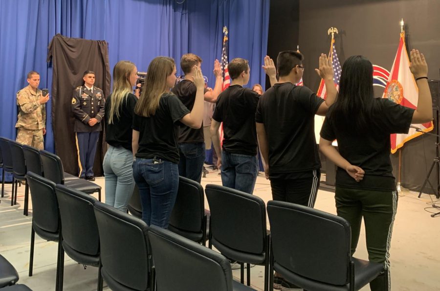 Six seniors from various Central Florida high schools hold their right hands up as they recite the United States Army Oath of Enlistment. One such student was senior Linsey Alexander, who plans to become a paratrooper.