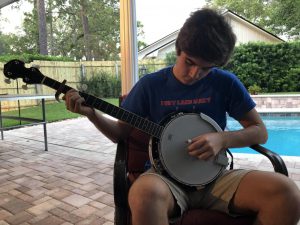 Senior Carson Cashion plays the banjo on his back porch on Tuesday, Apr. 7. Playing banjo is something he does not only to keep himself occupied, but to entertain both himself and his family during the quarantine.