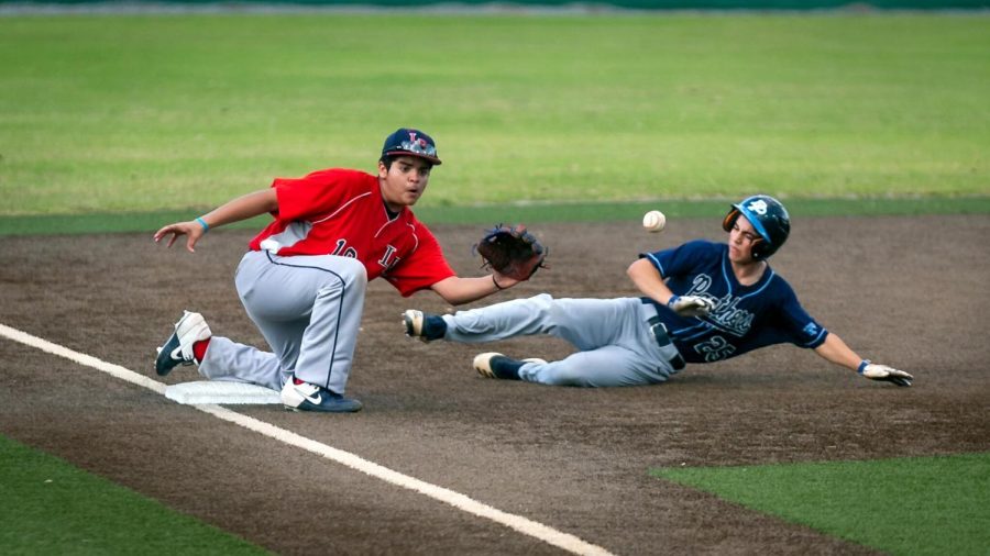 During the game against Dr. Phillips High School on March 4, freshman Jordan Sanchez slides to catch the ball from the catcher to tag out the runner.  “It’s a great feeling to know when you are helping your team out in any way, shape or form,”  Sanchez said.