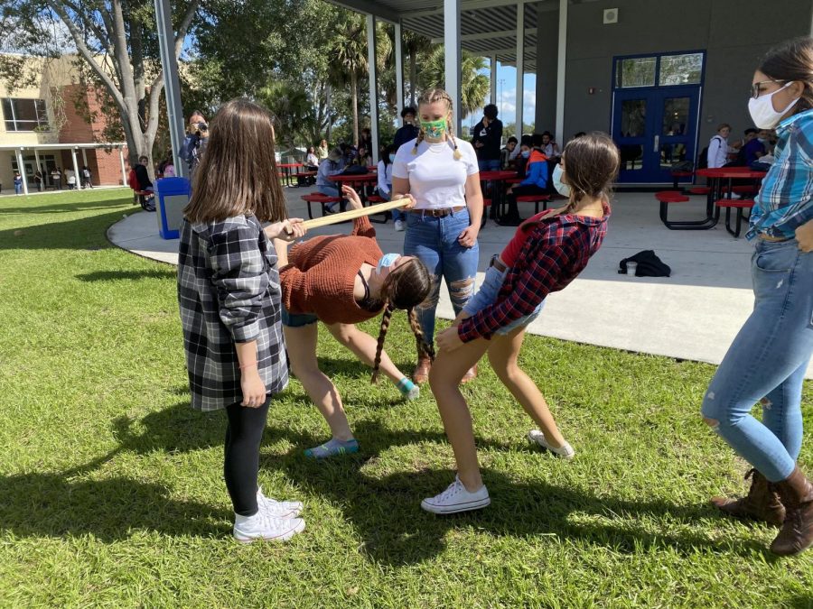 Seniors Emily Kirsch, Ashlynn Millis, and Veronica Vera participate in the limbo competition at C lunch on Wednesday, Nov. 4. Kirsch, Millis, and Vera are all Leadership students, and helped take the time to set up various festivities for students to participate in throughout the week.
