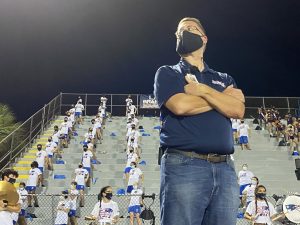 Band director Brad Wharton stands in front of the band as they perform a cadence. Wharton spent a lot of time leading up to the first game making sure it was safe for band members to perform.