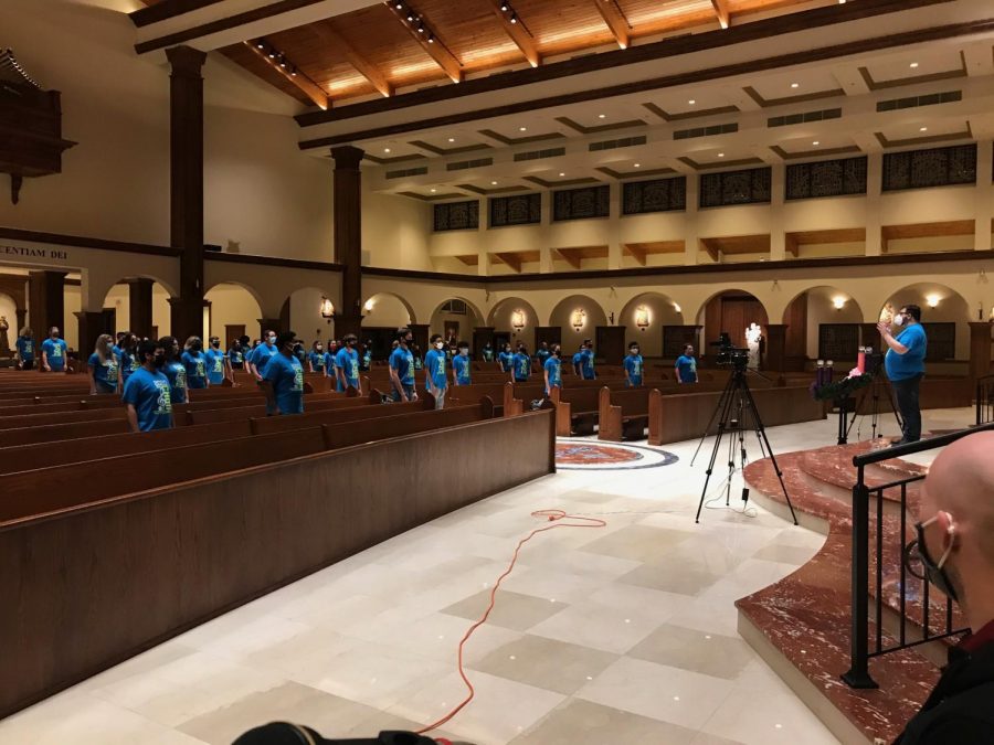 While socially distancing, chorus prepares for their first virtual concert at the Annunciation Catholic Church. Due to the COVID-19  pandemic students were distanced, masked, and could only sing for 30 minutes at a time.