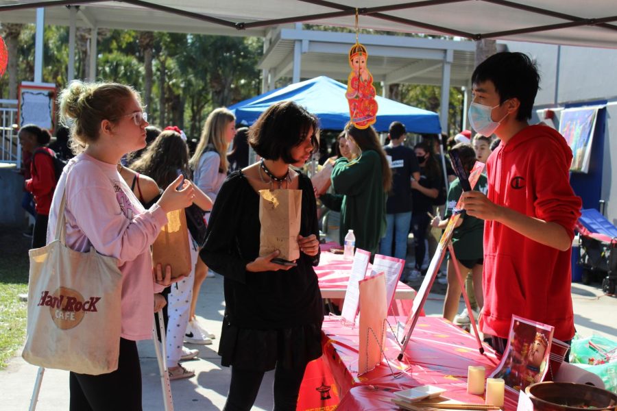 Junior Tao Chen explains to students how the Chinese lunar calendar works at the Winter Festival. The festival provided an opportunity to share different winter celebrations from different cultures and countries. “I felt proud of myself for sharing my culture with the rest of the school,” Chen said.